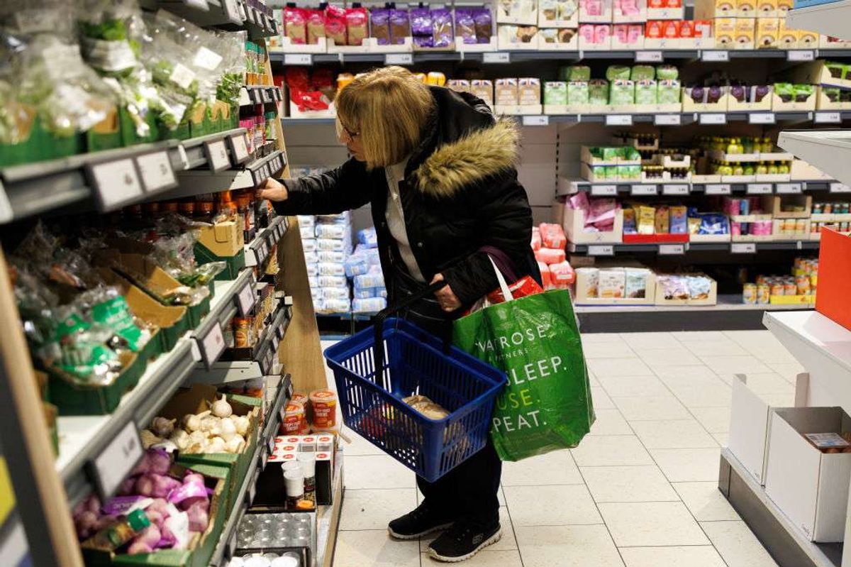 A customer looks at goods on a shelf in a supermarket