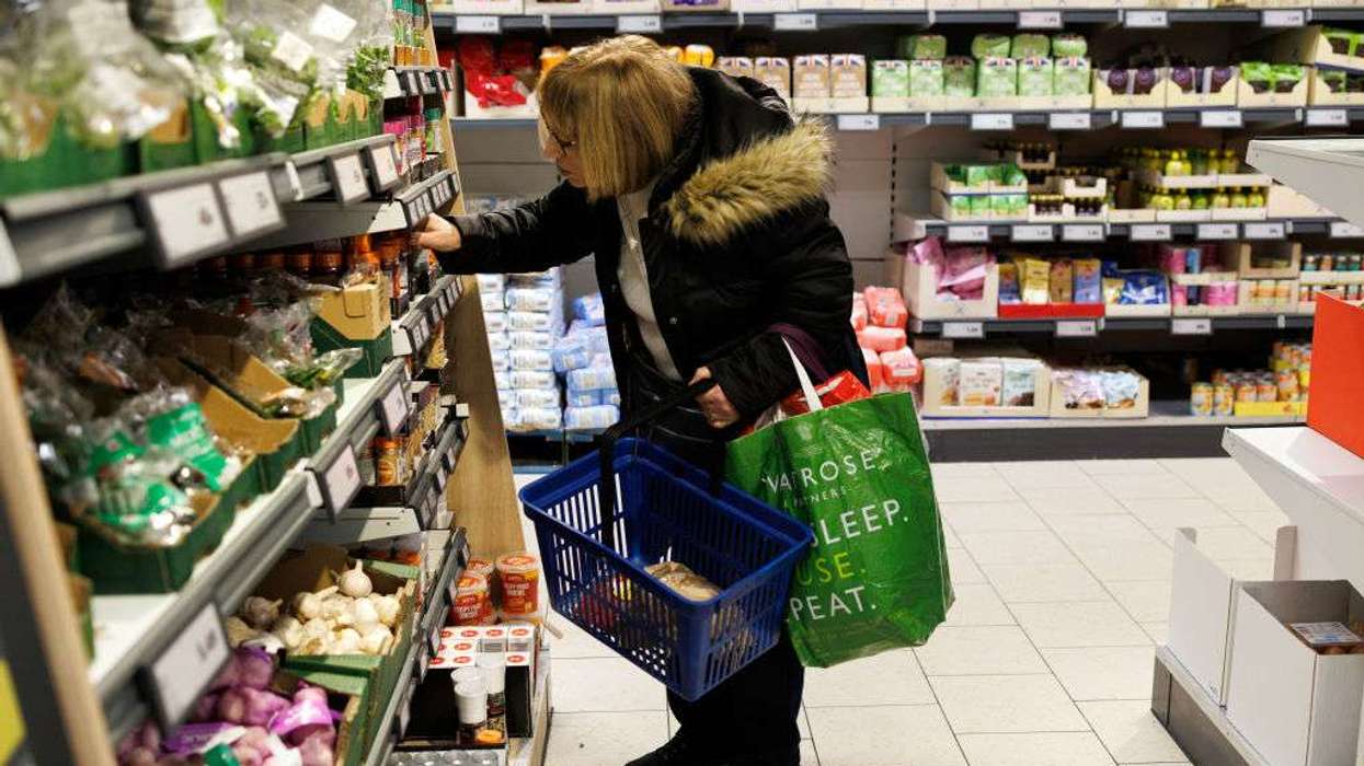 A customer looks at goods on a shelf in a supermarket
