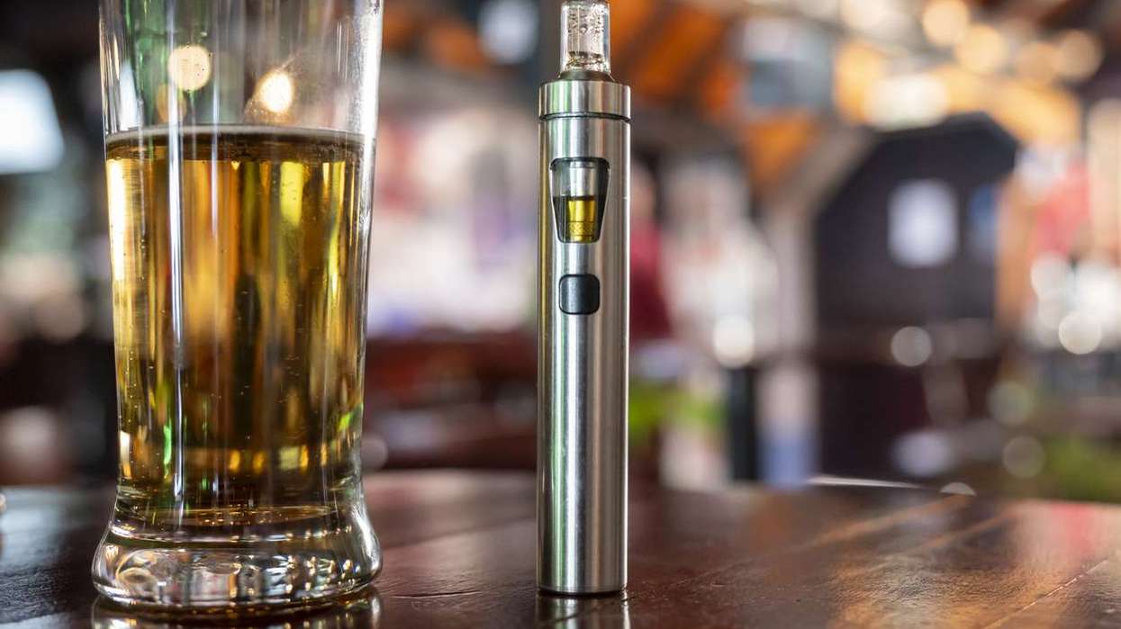 a glass of beer and a vape