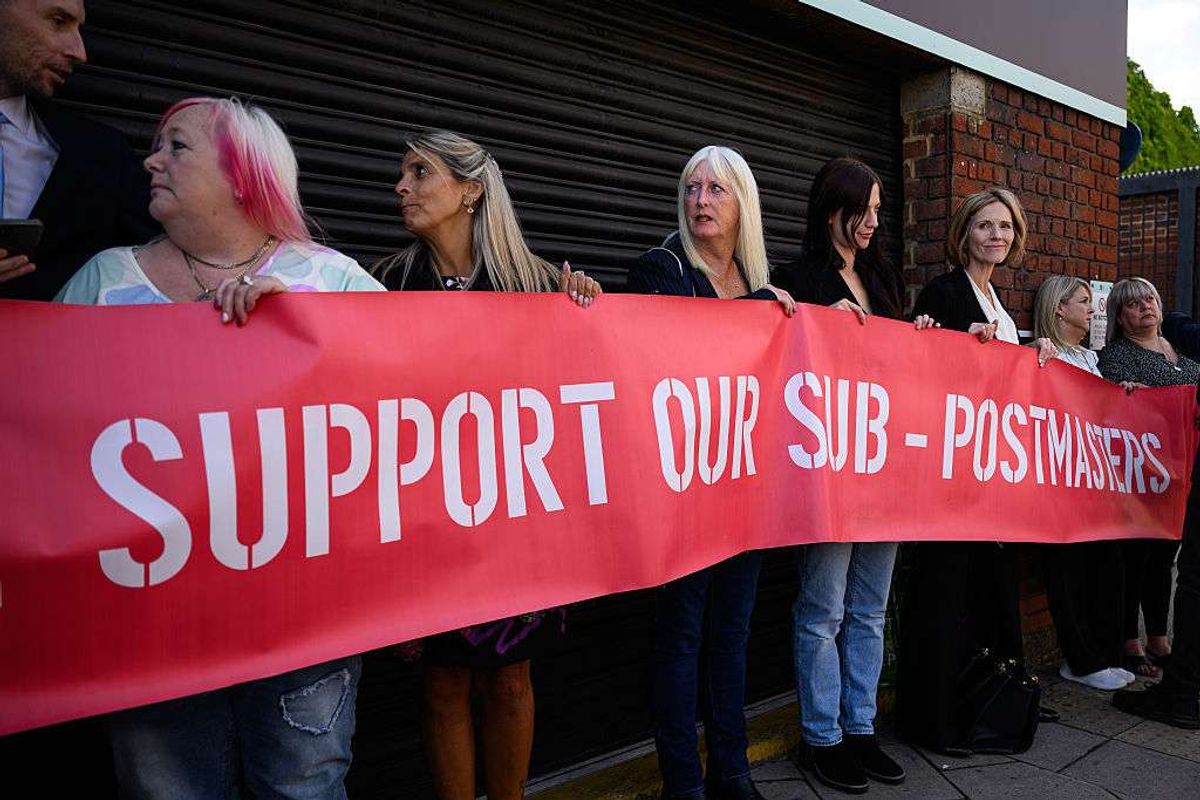 ​A group of those affected by the Horizon IT issue hold a banner