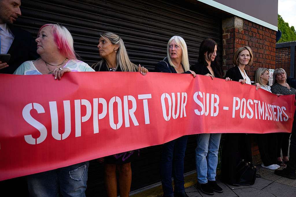A group of those affected by the Horizon IT issue hold a banner