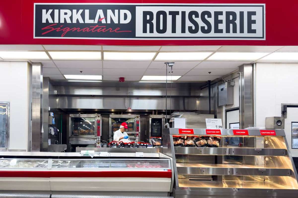 A Kirkland Signature rotisserie chicken station inside a Costco warehouse