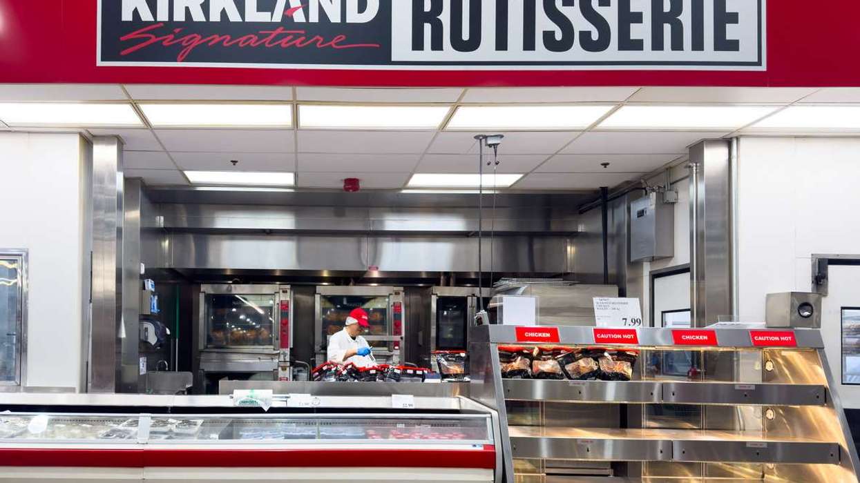 A Kirkland Signature rotisserie chicken station inside a Costco warehouse