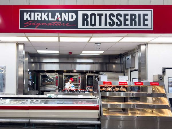 A Kirkland Signature rotisserie chicken station inside a Costco warehouse