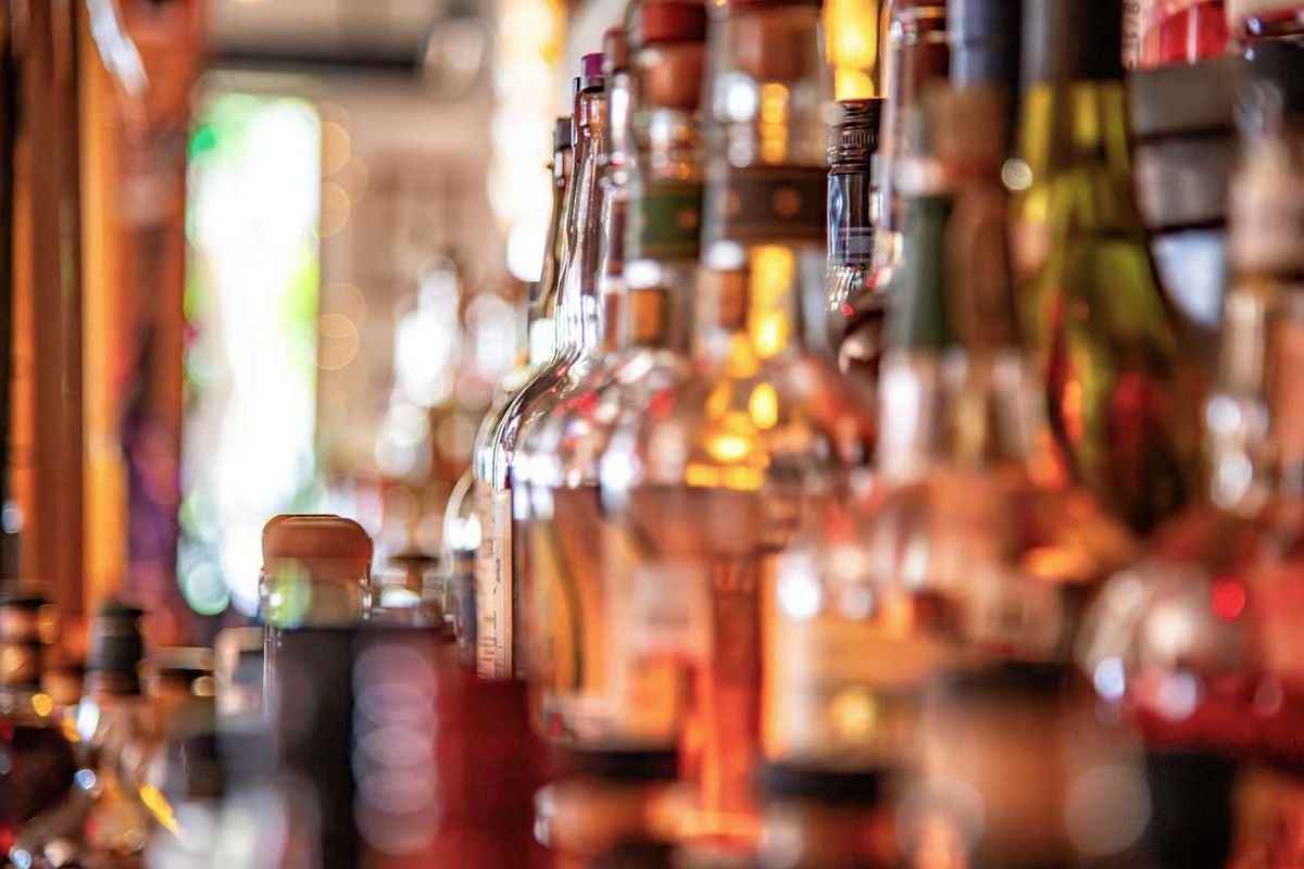 A large group of liquor bottles on display on a shelf