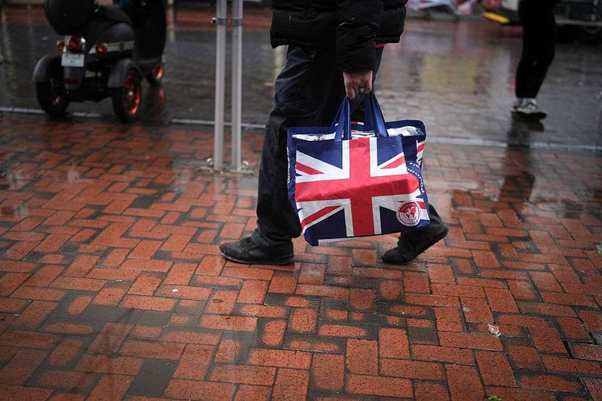 A man carries a Union Jack patterned shopping bag