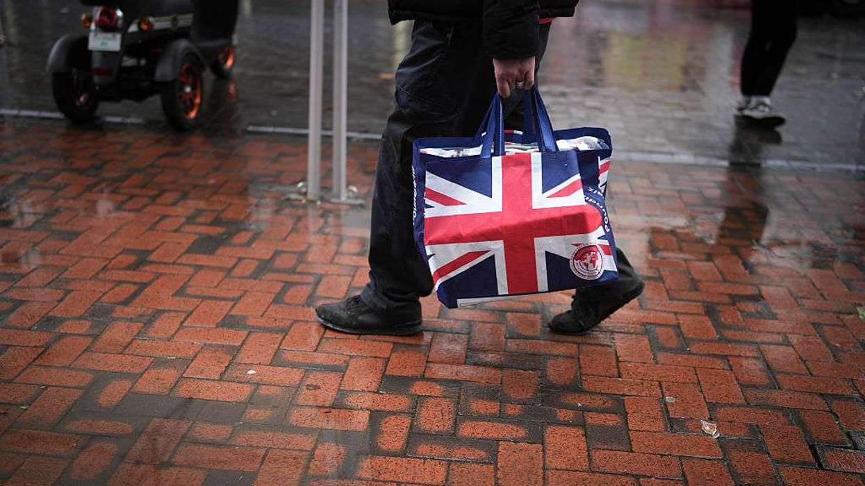 A man carries a Union Jack patterned shopping bag