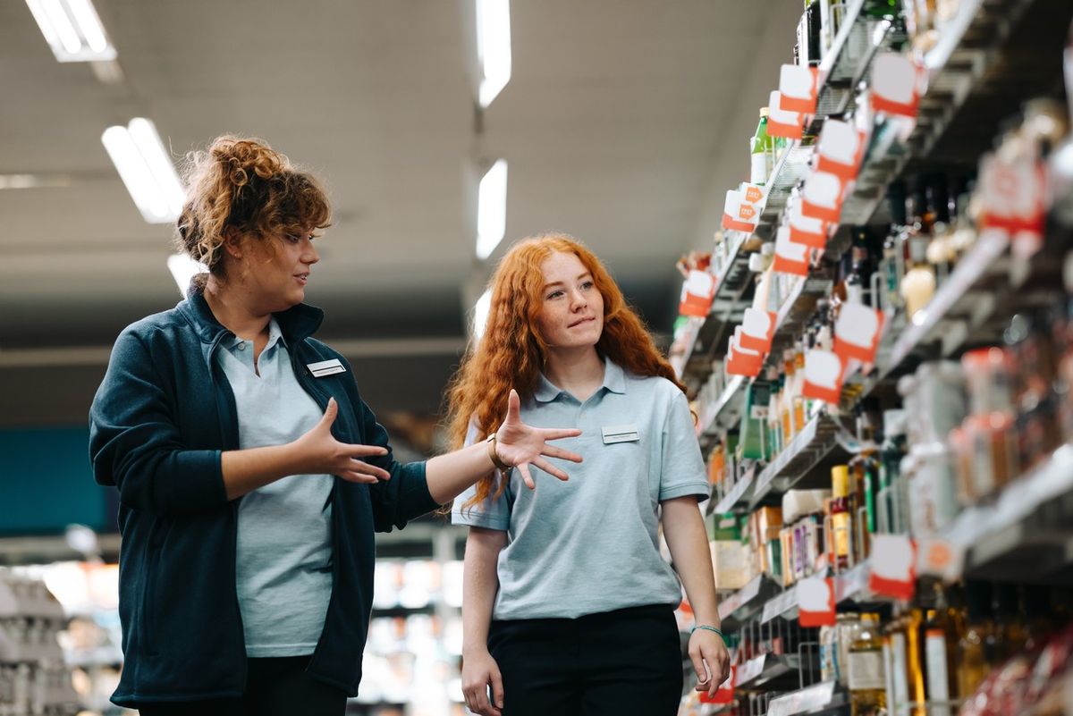 A retailer giving training to a part-time employee