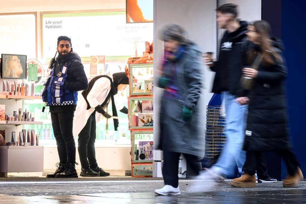 A security guard stands in the doorway of a store in London, England