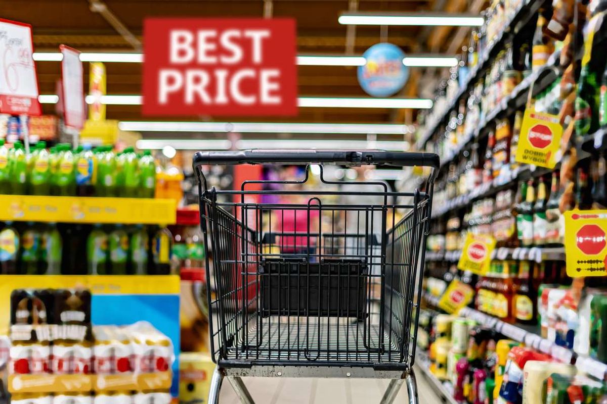 A shopping cart by a store shelf in a supermarket
