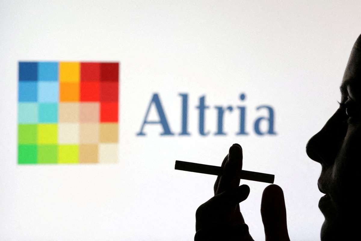 A woman poses with a cigarette in front of Altria logo in this illustration taken July 26, 2022