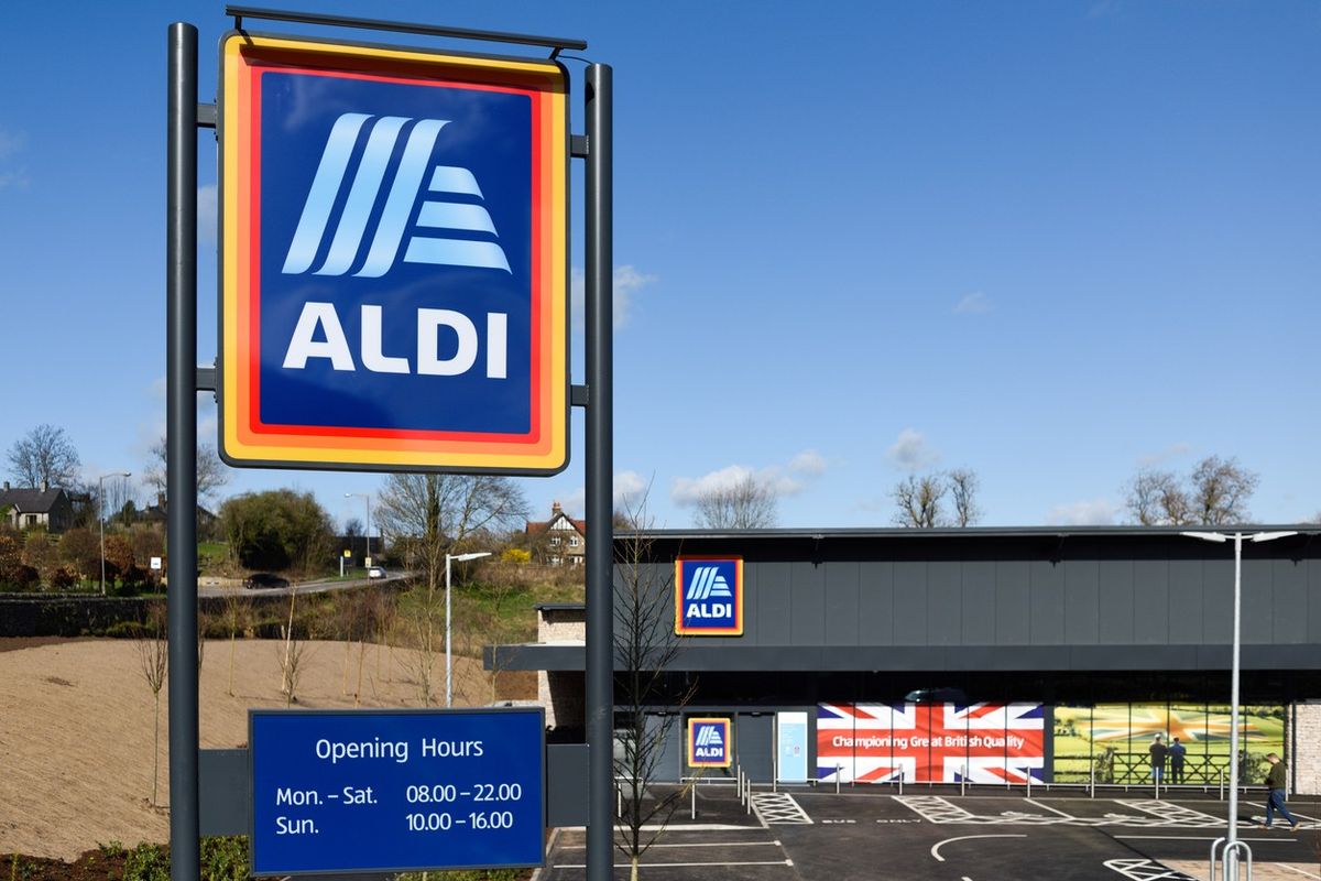 Aldi supermarket exterior with store sign and opening hours displayed prominently