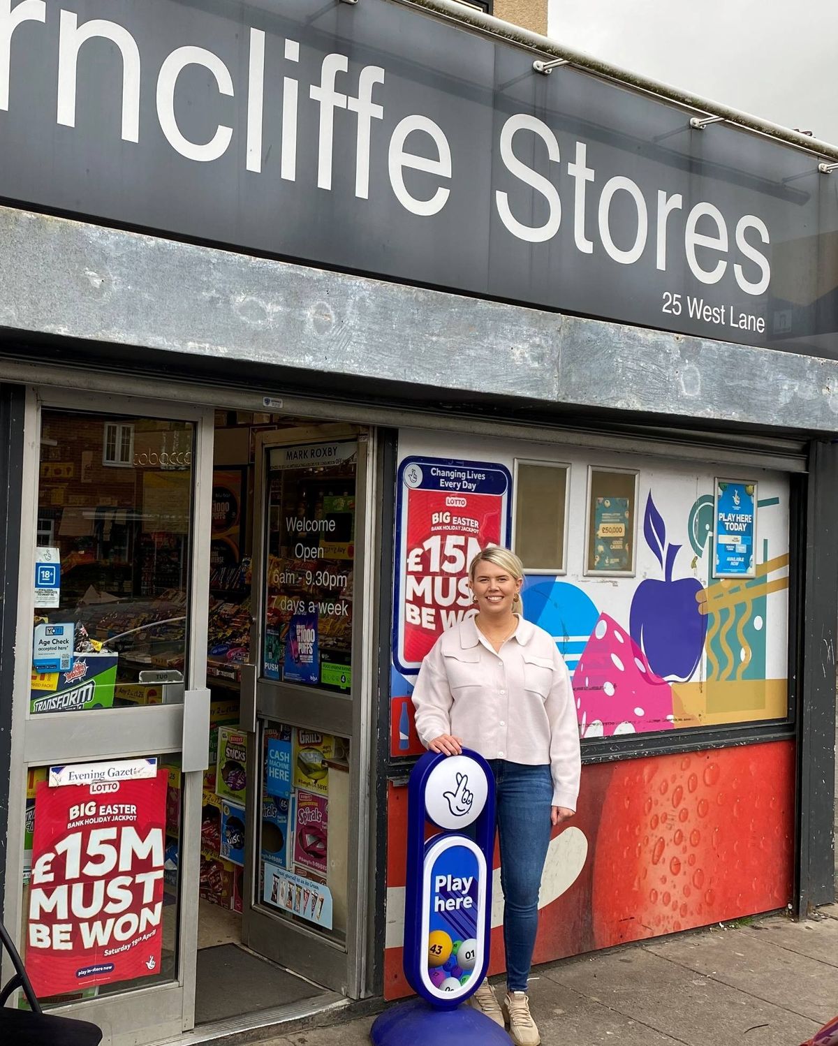 Amy Fowler of Arncliffe Stores holding Allwyn cheque for £10,000 lottery prize