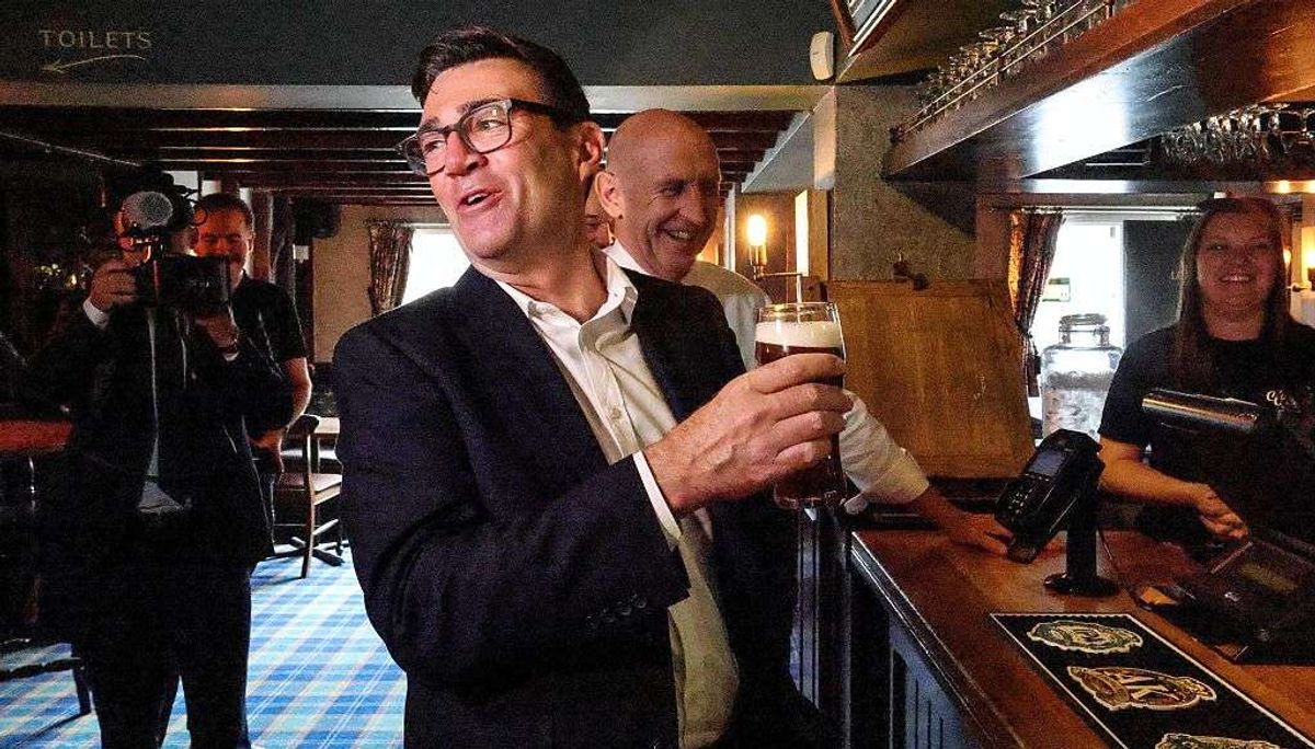 Andy Burnham holding a pint of beer 