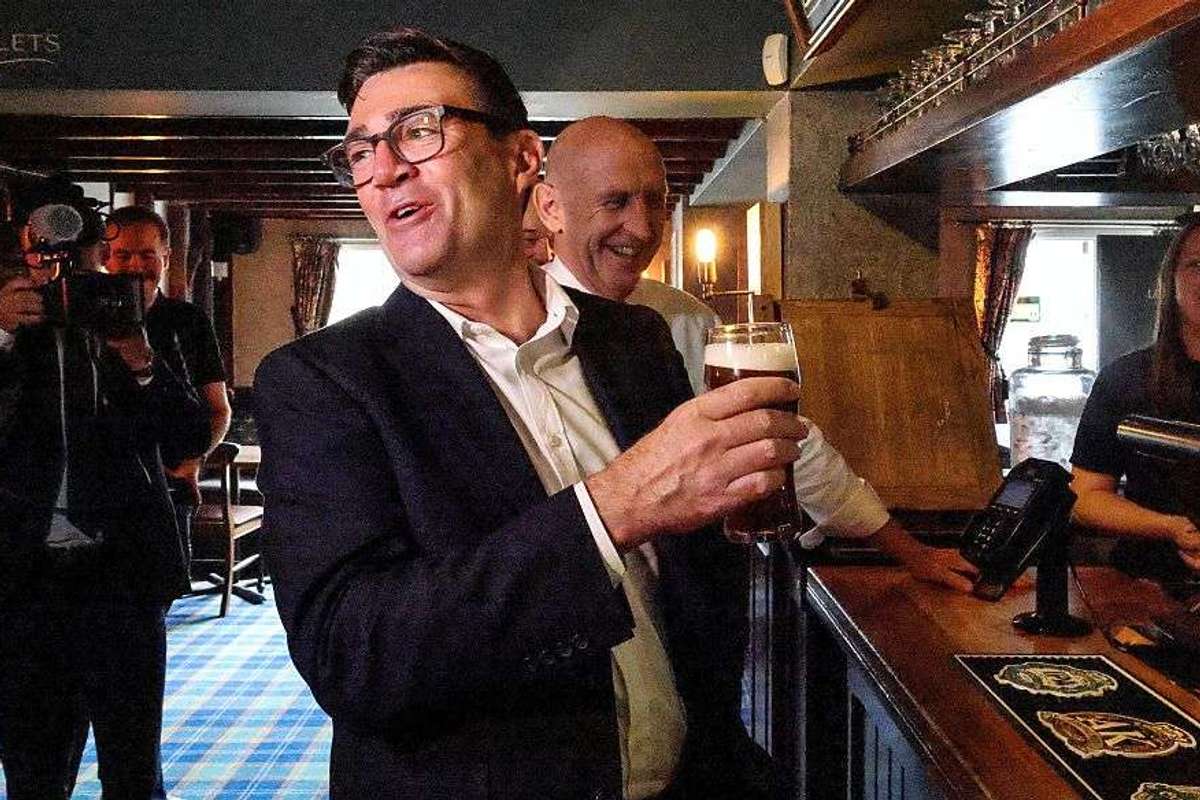 Andy Burnham holding a pint of beer