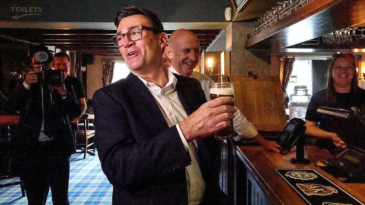 Andy Burnham holding a pint of beer