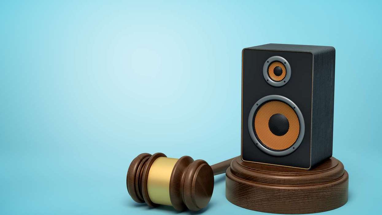 audio loudspeaker on round wooden block and brown wooden gavel