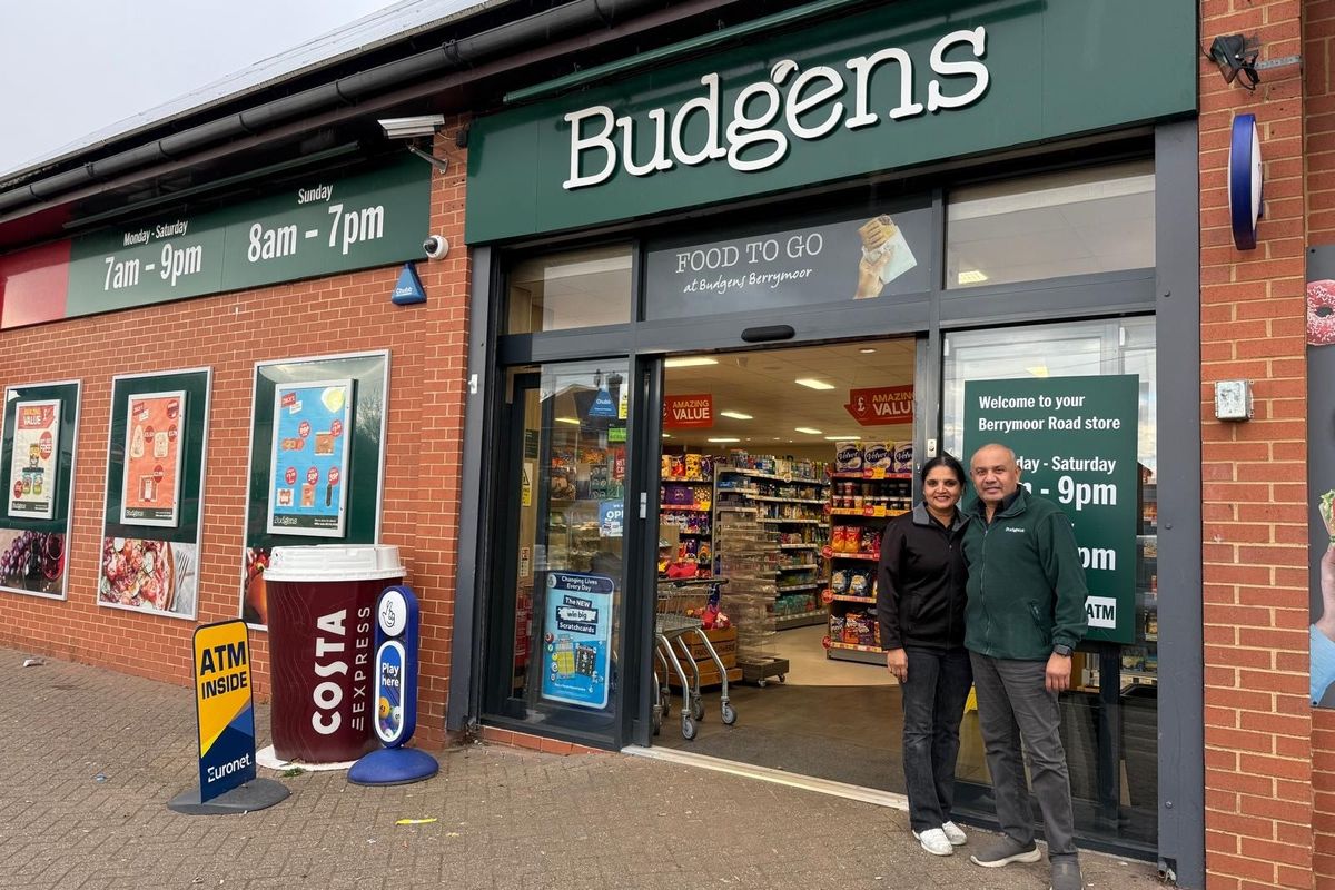 Budgens Berrymoor storefront in Wellingborough with Costa Express machine, ATM, and owners standing outside