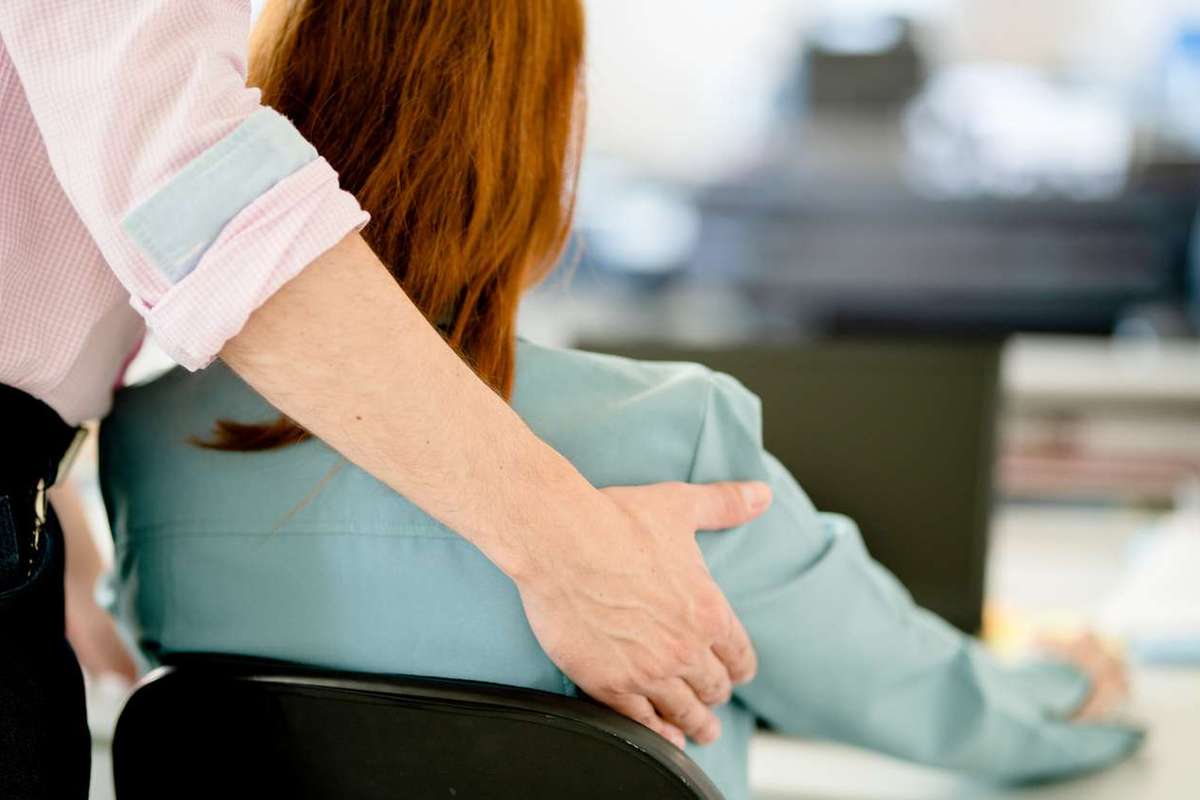 Businessman sexually harassing a female colleague in an office