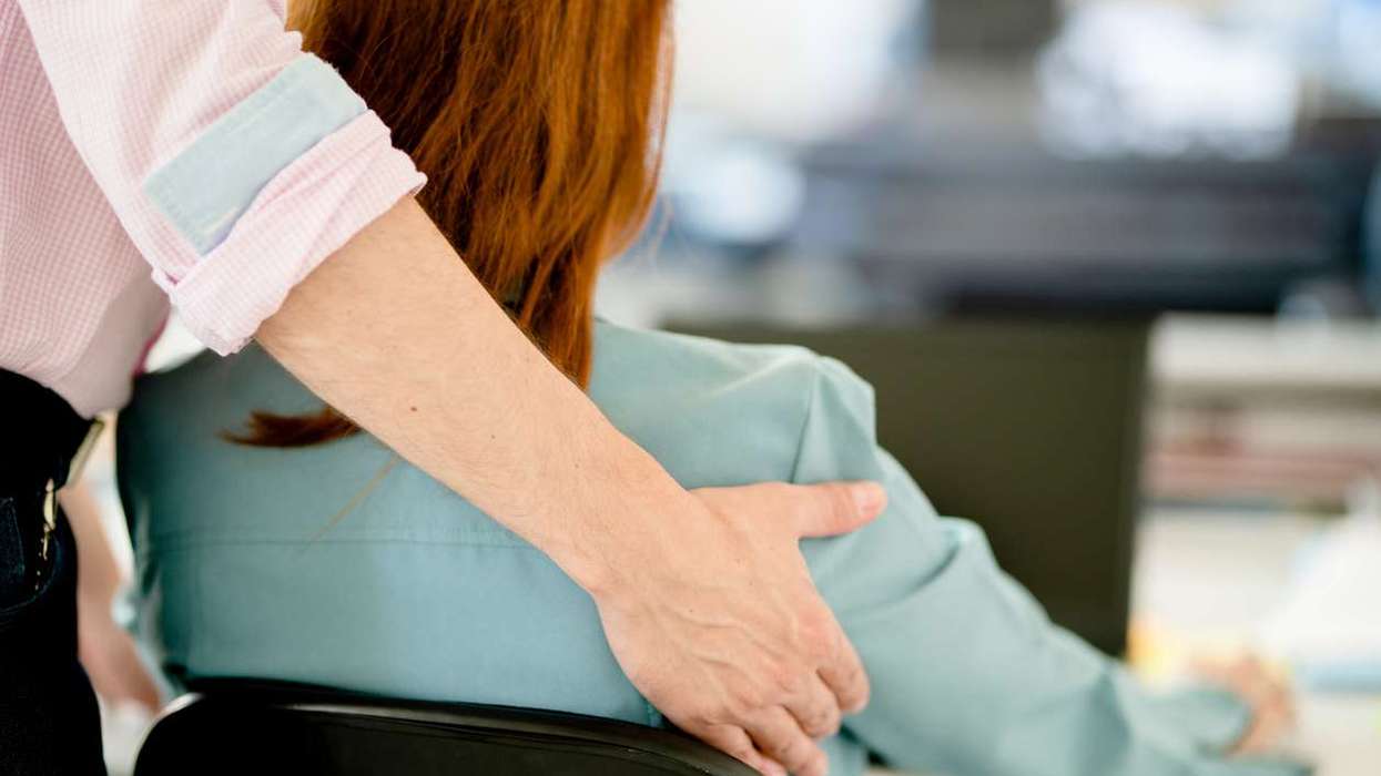 Businessman sexually harassing a female colleague in an office