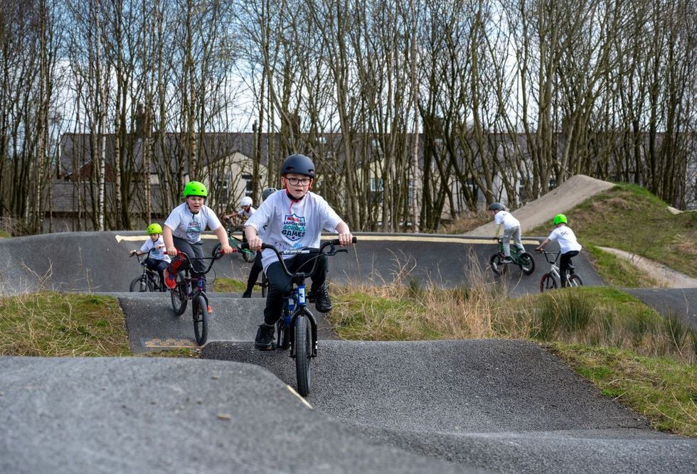 Children wearing SPAR Lancashire School Games shirts practicing BMX at Pennine skatepark