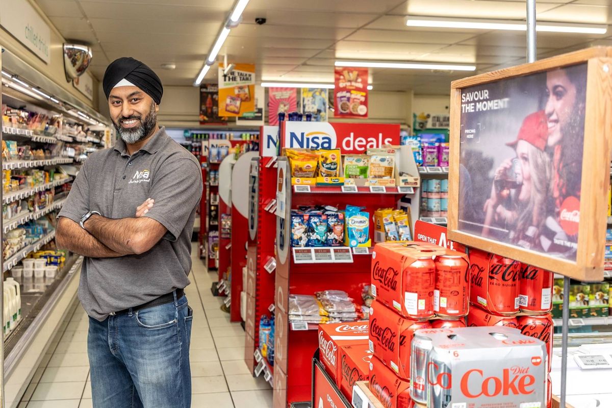Coca-Cola 125 Years UK campaign poster spotlighting local convenience store owner with shop front