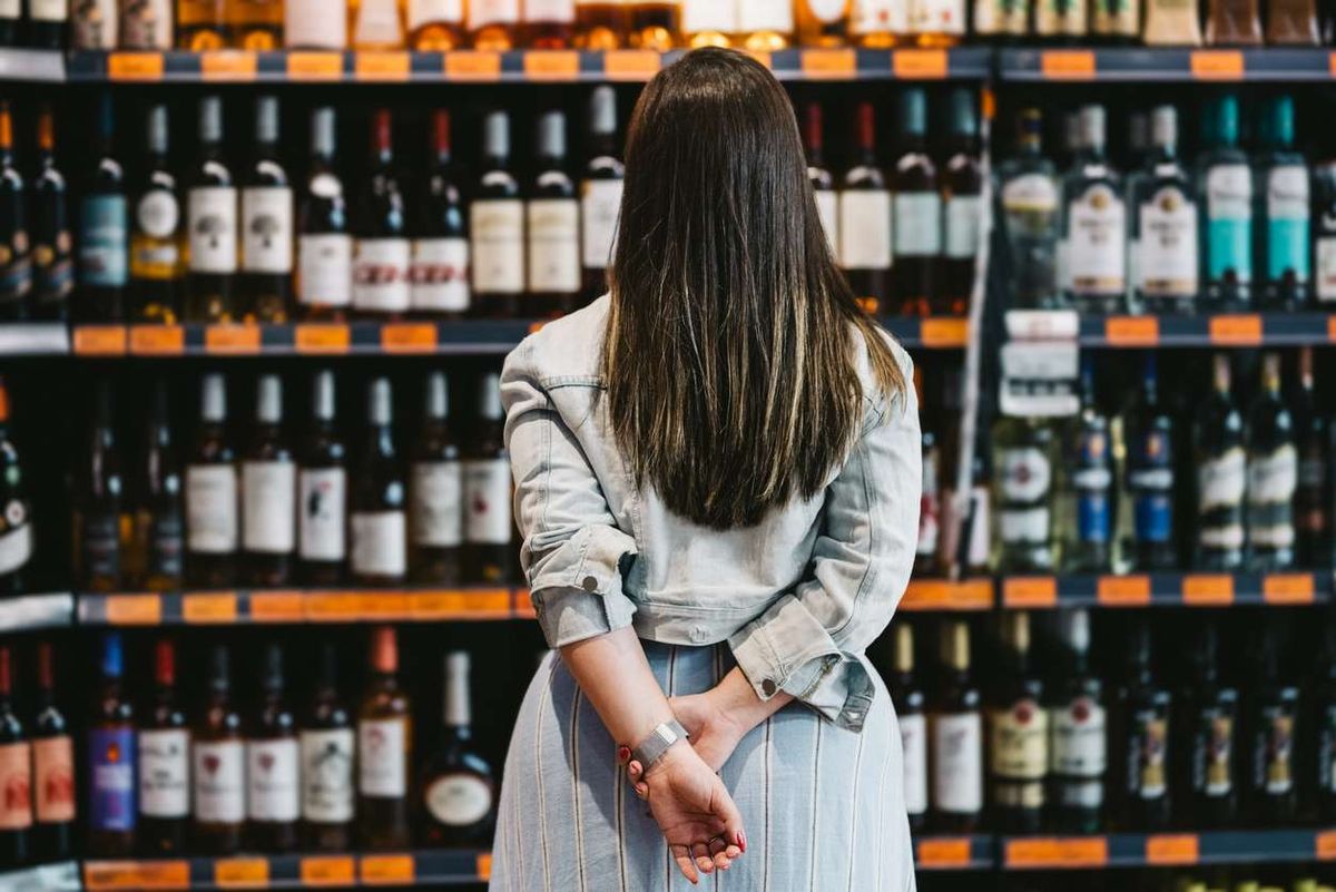  customer looking at a rack of wine and spirits in supermarket