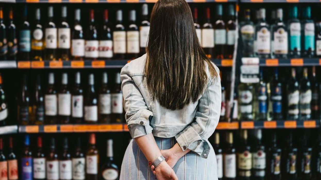 customer looking at a rack of wine and spirits in supermarket