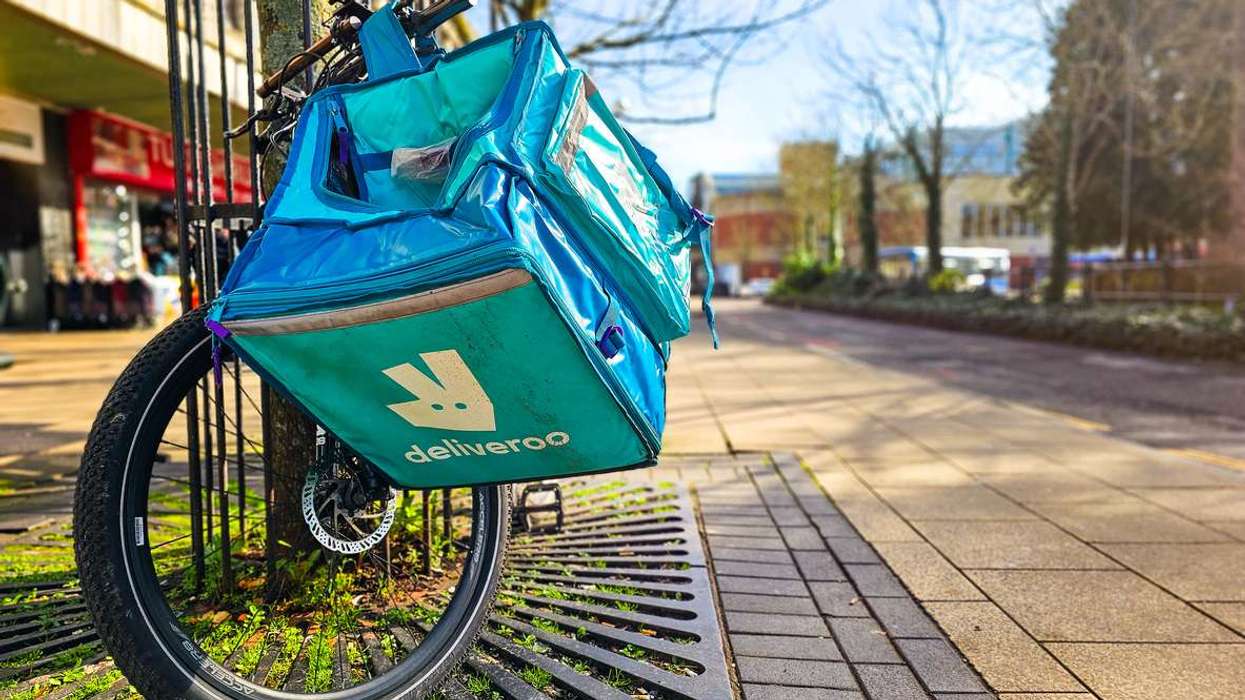 Deliveroo courier bicycle equipped with blue thermal delivery bag