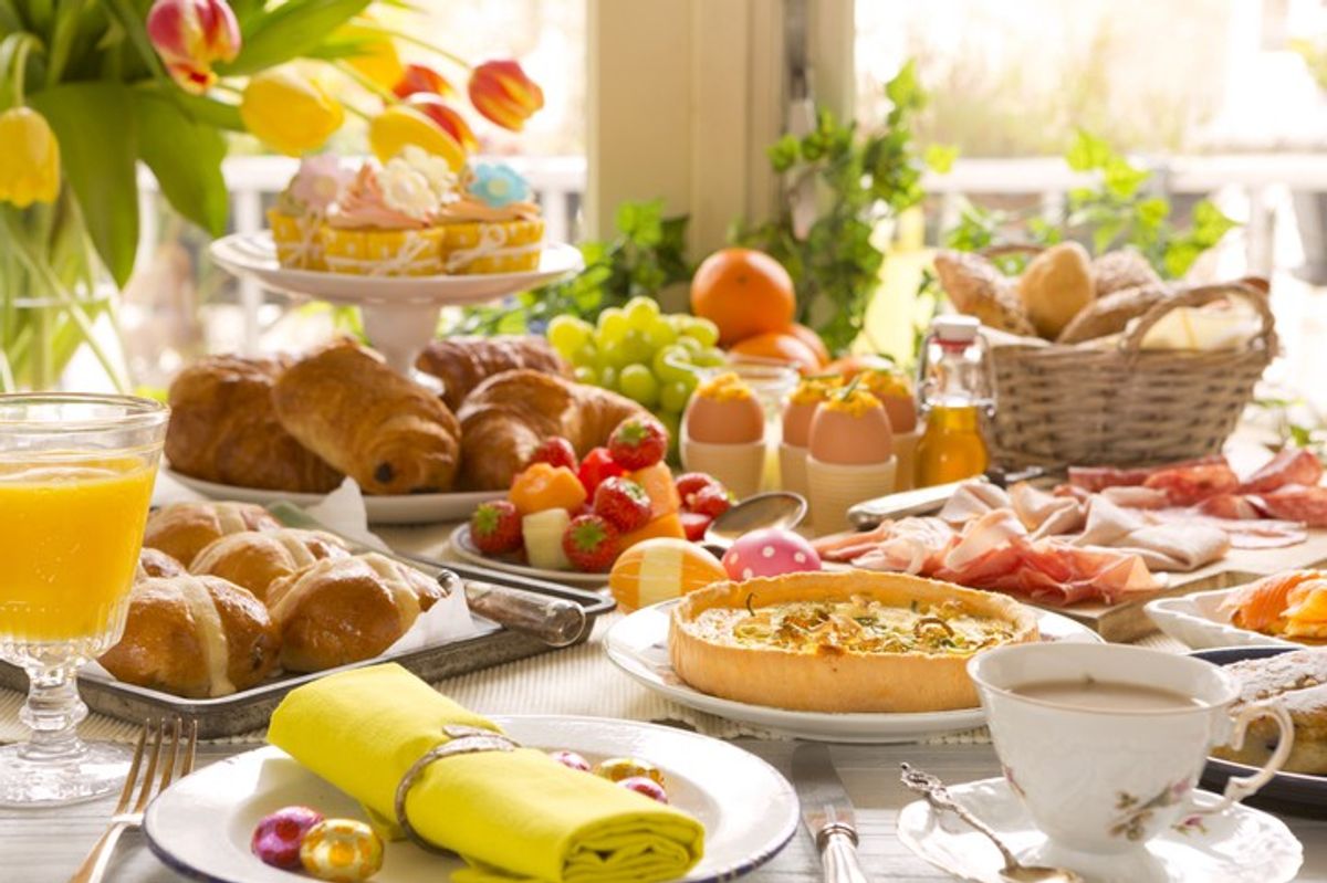 Easter brunch table with hot cross buns, eggs benedict and floral decor inspired by Waitrose.