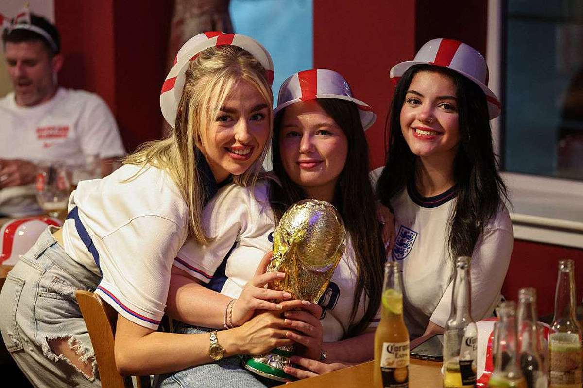 England supporters pose with a replica of FIFA trophy