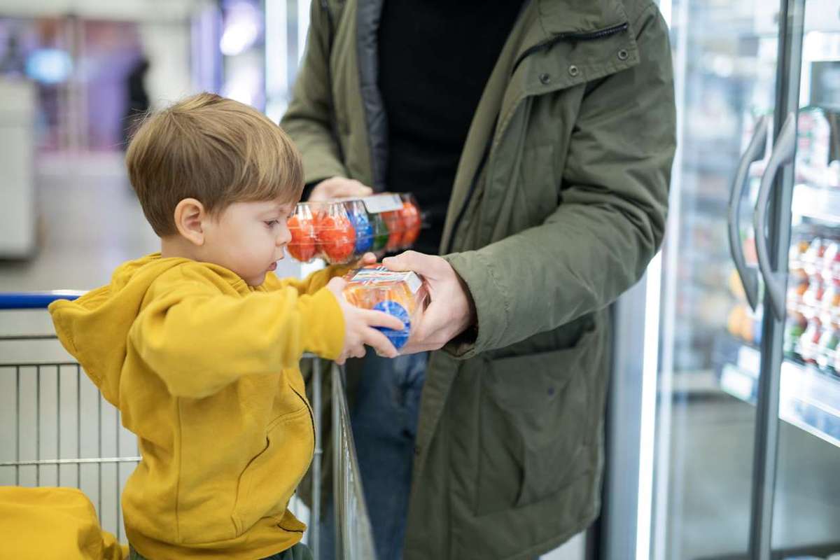 Father and son shopping Easter eggs in supermarket