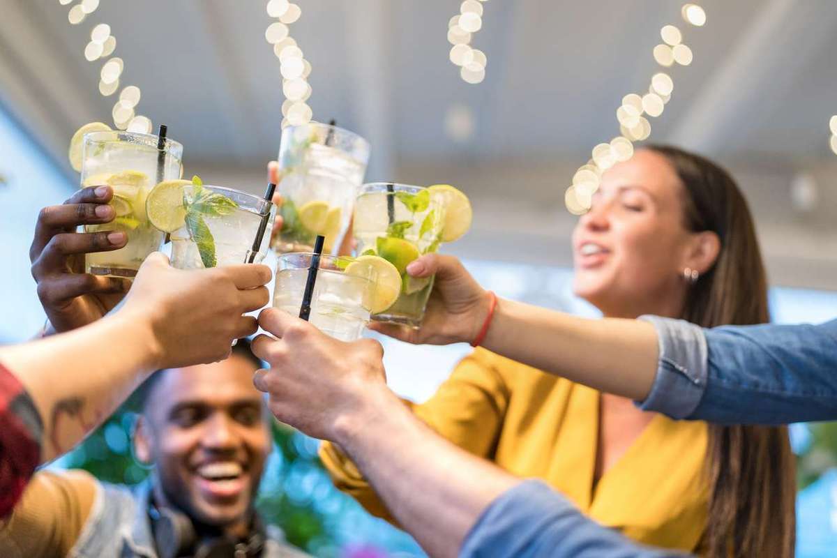 Gen Z friends drinking mojito cocktails