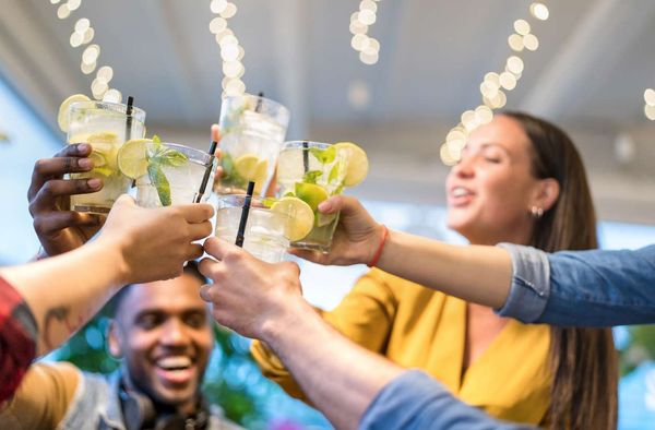 Gen Z friends drinking mojito cocktails