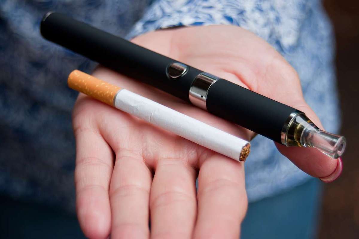 Hand of woman with an e-cigarette and a cigarette