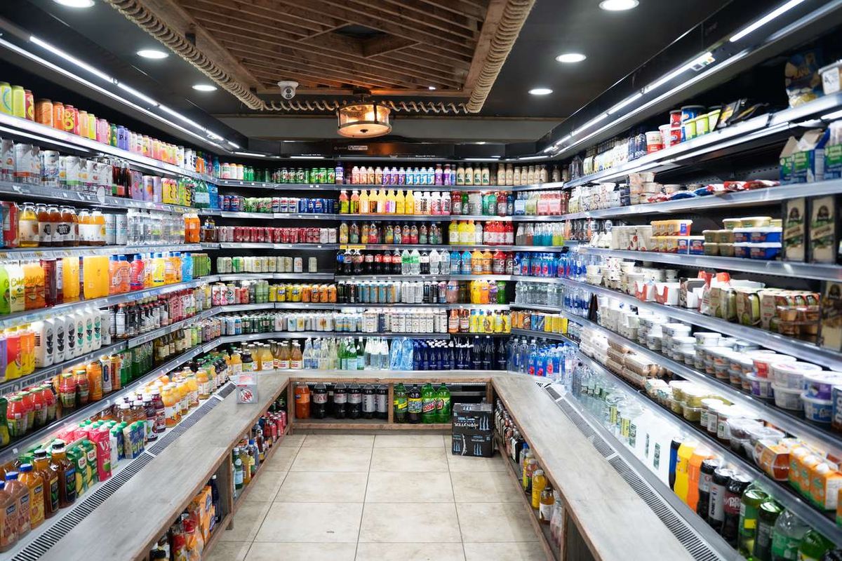 Interior of a modern convenience store with rows of refrigerated drinks