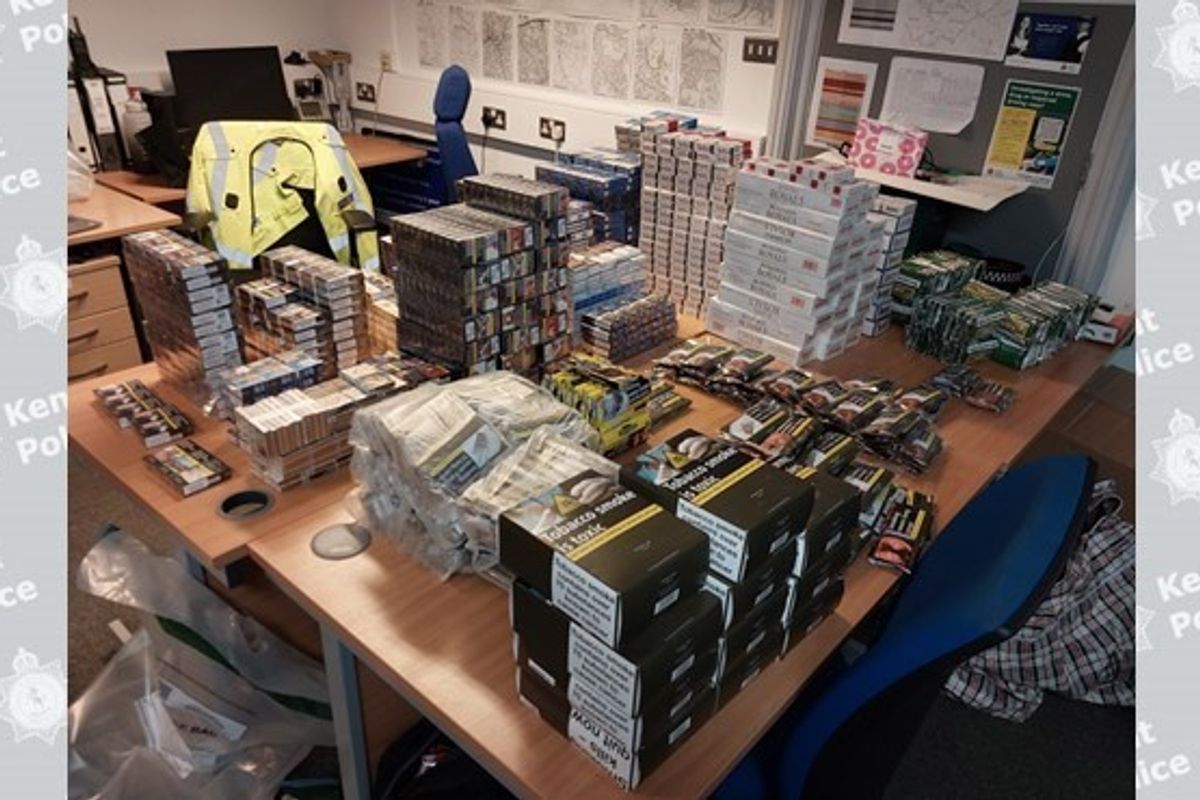 Kent Police officer inspecting 20kg of illicit tobacco at Upper Stone Street shop, revealing illicit tobacco dangers in Maidstone.