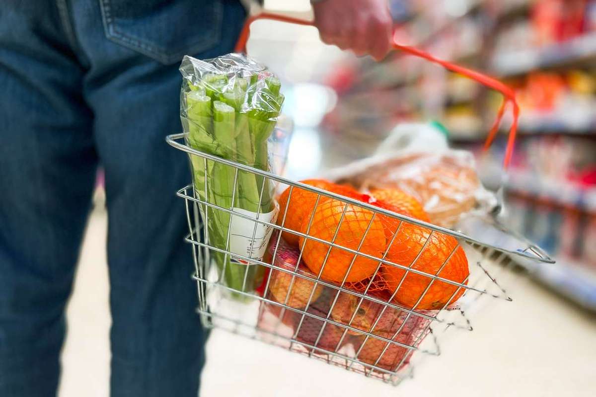 Man holding shopping basket full of healthy groceries