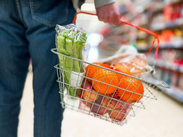 Man holding shopping basket full of healthy groceries