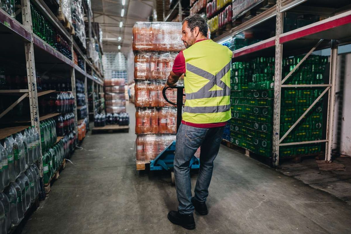 man pulling a hand truck at a supermarket warehouse