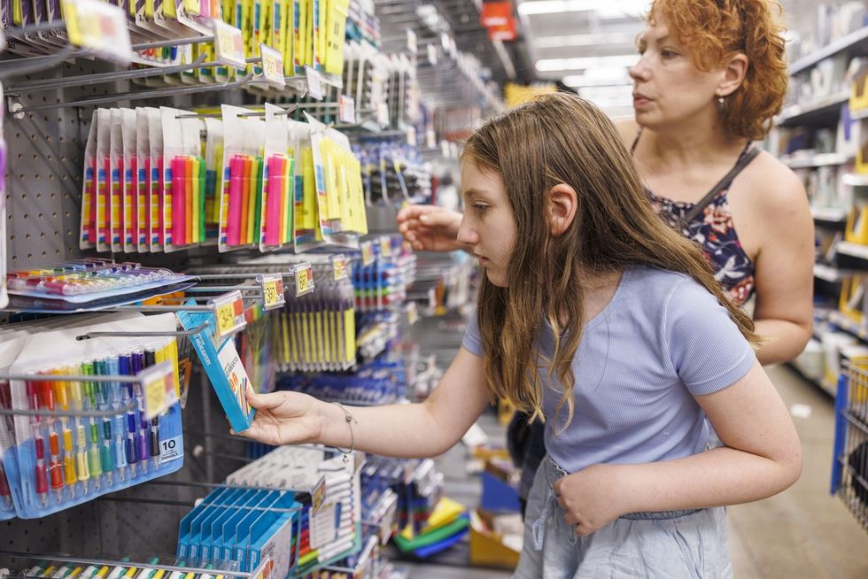 Mother guides daughter through colorful stationery aisle