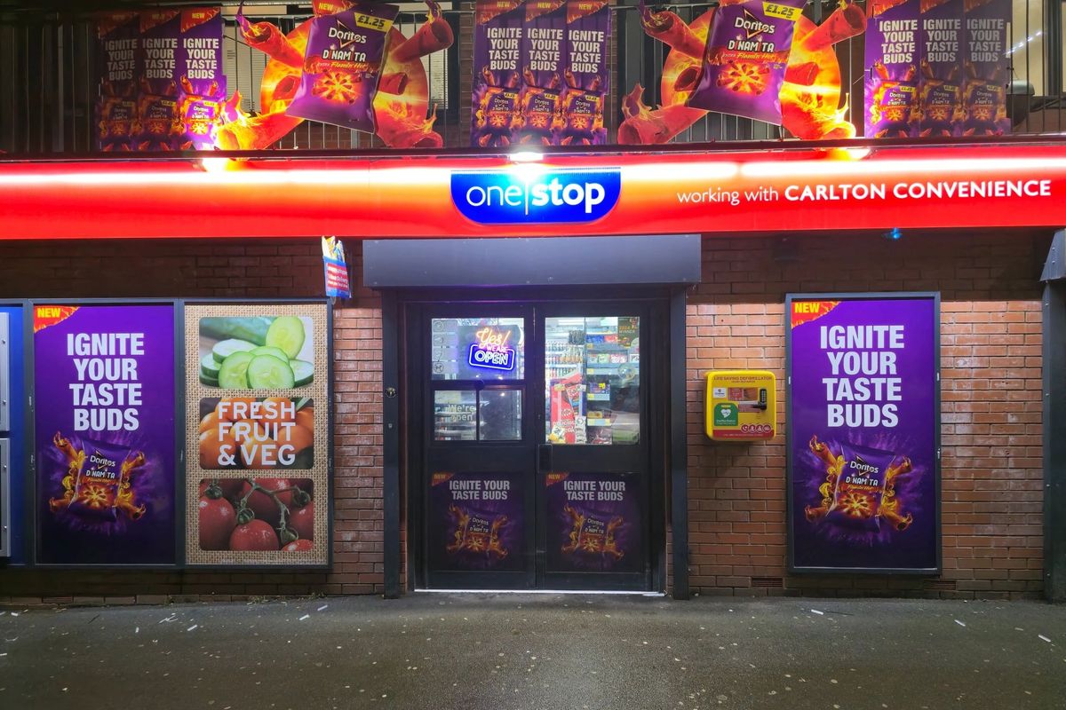One Stop Carlton storefront in Manchester with Doritos Dinamita activation, featuring purple window vinyls and fiery branding