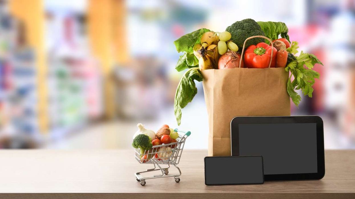 Online grocery shopping background with devices and shopping bag in supermarket