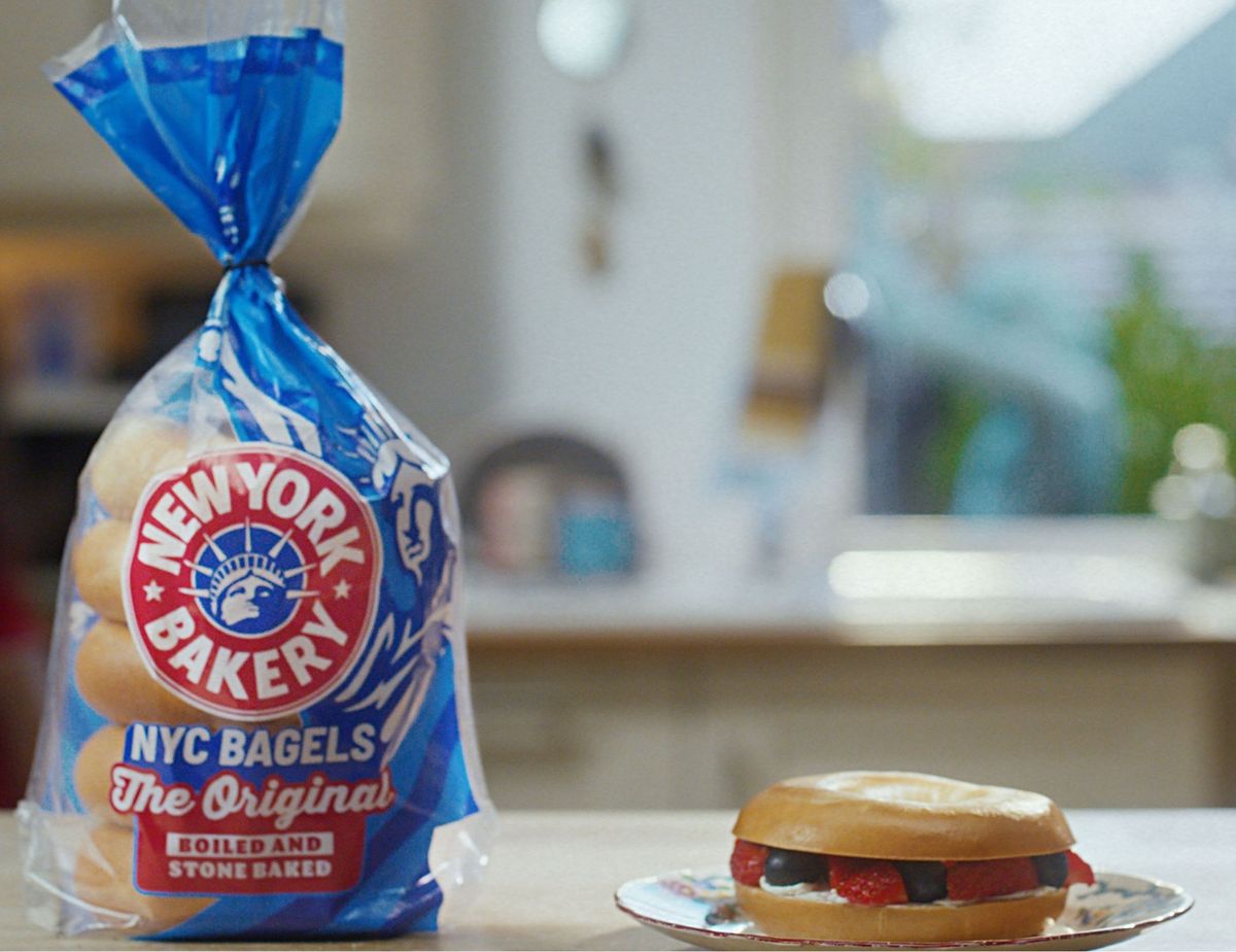 Pack of New York Bakery Original Bagels with a fresh bagel sandwich served on a plate in a kitchen setting