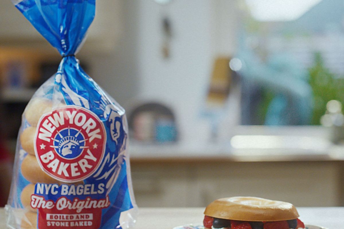 Pack of New York Bakery Original Bagels with a fresh bagel sandwich served on a plate in a kitchen setting