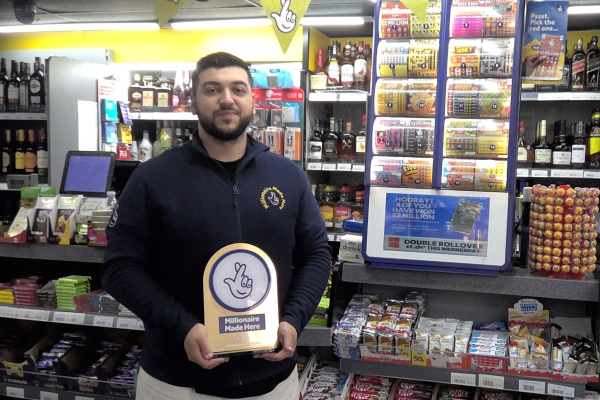 Retailer holds 'Millionaire Made Here' award in lottery ticket store
