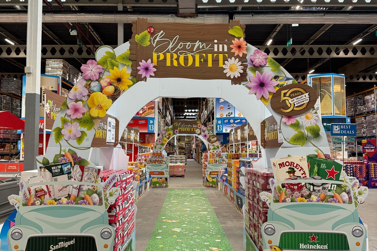 Retailers walking through Easter-themed archway at Bestway depot filled with product deals