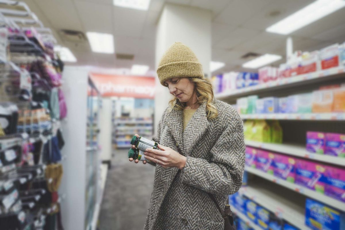 Shopper checking over-the-counter medicines at a convenience store 