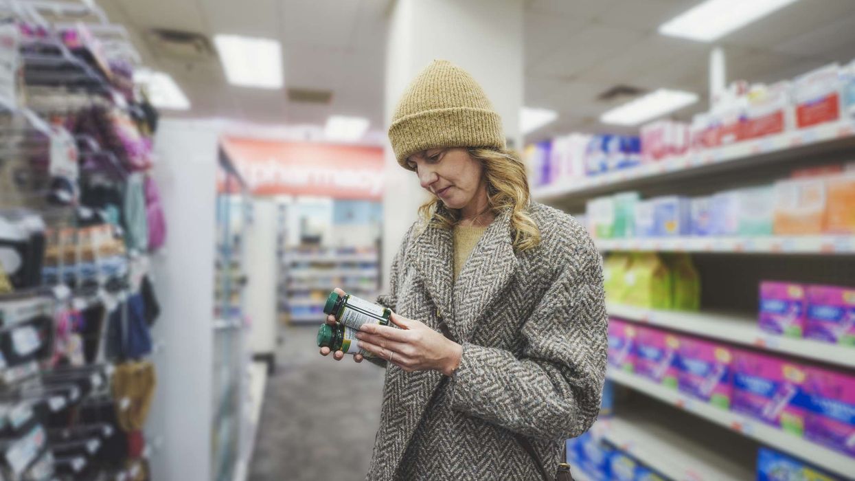 Shopper checking over-the-counter medicines at a convenience store