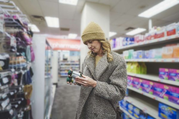 Shopper checking over-the-counter medicines at a convenience store